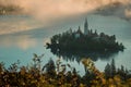 Panoramic photo of lake Bled island with church on a cold hazy foggy early autumn morning from Ojstrica vantage point. Visible fog Royalty Free Stock Photo