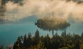 Panoramic photo of lake Bled island with church on a cold hazy foggy early autumn morning from Ojstrica vantage point. Visible fog Royalty Free Stock Photo