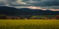 Panoramic photo of Povazsky Inovec Hill in Slovakia with small village in the valley on sunset. Landscape photo of wheat field