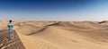 Panoramic photograph of a man on top of a dune in the Abu Dhabi desert. UAE Royalty Free Stock Photo