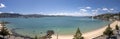 Panoramic picture of a beach in Wellington in New Zealand under a blue sky surrounded by greenery