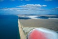 Panoramic picturesque aerial view of the sea coast with a pink lake separated from the sea by a narrow sandy spit.