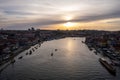 Panoramic of the Porto river with the houses on both sides and the sunset sun in the background.