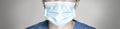 Panoramic portrait of female doctor or nurse wearing protective medical mask