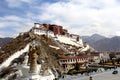 The panoramic of the Potala Palace, with the people republic of China flag inside as well as Potala Palace square, trees and meado