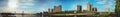 Panoramic reflection of riverbank trees, buildings and bridges Royalty Free Stock Photo