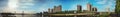 Panoramic reflection of riverbank trees, buildings and bridges Royalty Free Stock Photo