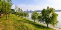 Panoramic reflection of riverbank trees, buildings and bridges