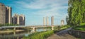 Panoramic reflection of riverbank trees, buildings and bridges