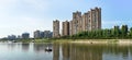 Panoramic reflection of riverbank trees, buildings and bridges