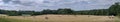 Panoramic of Round baller in the meadows Royalty Free Stock Photo