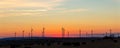 Panoramic scenic landscape view new modern wind turbine farm power generation station against fiery warm sunset sky Royalty Free Stock Photo