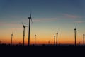 Panoramic scenic landscape view new modern wind turbine farm power generation station against fiery warm sunset sky Royalty Free Stock Photo