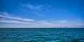 Panoramic seascape on a bright summer day with few sailing boats afar, great sky with beautiful clouds. Peaceful