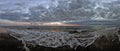 Panoramic seaside sunset at winter season with dramatic sky with dark stratocumulus clouds and rough sea with lots of white sea Royalty Free Stock Photo