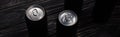 Panoramic shot of black aluminum cans of beer on wooden table .