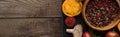 Panoramic shot of black tray with pepper and salt in bowls, chilli pepper, sliced tomatoes and garlic on wooden table. Royalty Free Stock Photo