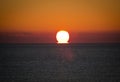 Panoramic shot of bright sunset with the large yellow sun under the sea surface Royalty Free Stock Photo