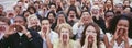 Panoramic shot of crowd shouting with hands on face