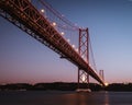 Panoramic shot of the 25 de Abril Bridge located in Lisbon, Portugal at an evening Royalty Free Stock Photo