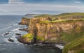 Panoramic shot of Dunluce Castle at sunset located on the edge of cliff, Northern Ireland Royalty Free Stock Photo