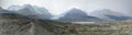 Panoramic shot of a field with mountains in the distance under a cloudy sky at Columbia Icefield Royalty Free Stock Photo