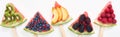 Panoramic shot of fresh watermelon on sticks with seasonal berries and fruits on white background. Royalty Free Stock Photo