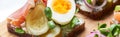Panoramic shot of ham, pickled cucumber and half of boiled egg on danish smorrebrod. Royalty Free Stock Photo