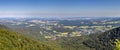 Panoramic shot from hill peak to valley with villages under summer blue sky