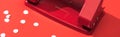 Panoramic shot of holepunch with paper circles on red background. Royalty Free Stock Photo