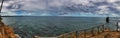 Panoramic shot of the ocean under the cloudy and rainy sky