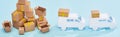 Panoramic shot of pile of cardboard boxes near mini trucks on blue background. Royalty Free Stock Photo