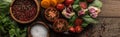 Panoramic shot of plate with spinach, garlic and sliced tomatoes near scattered pepper and bowls on wooden table. Royalty Free Stock Photo