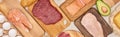 Panoramic shot raw meat, fish and poultry on wooden cutting boards near chicken eggs and half of avocado. Royalty Free Stock Photo