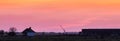 Panoramic shot of a rural farmstead at sunset, featuring a barn