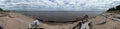 Panoramic shot of a sandy coast with a cloudscape
