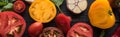 Panoramic shot of scattered spinach, sliced tomatoes and garlic on black tray on wooden table. Royalty Free Stock Photo