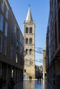 Panoramic shot of a shaded street with the Church of St. Donatus bell tower in the background