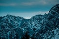 Panoramic shot of snow covered jagged mountain peaks under cloudy blue skies Royalty Free Stock Photo