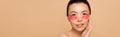 Panoramic shot of tender asian woman with pink collagen eye pads