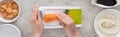 Panoramic shot of woman grating carrot among ingredients. Royalty Free Stock Photo