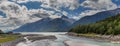 Panoramic shot of Yucatania point and shallow Skagway river in Skagway, Alaska. Mountains and cloudy blue sky as a background Royalty Free Stock Photo