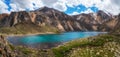 Panoramic spring view to mountain lake on background of mountains. Atmospheric green landscape with lake in high mountain valley. Royalty Free Stock Photo