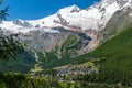 Panoramic summer view of Saas-Fee holiday village and surrounding mountains from Saas-Grund, Valais, Switzerland Royalty Free Stock Photo