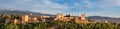 Panoramic sunset hour time of Alhambra medieval palace and fortress complex with Sierra Nevada snowy mountains in Granada, Royalty Free Stock Photo