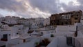 Panoramic timelpase of Vejer de la Frontera white town with house rooftops at sunset with dramatic sky