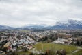 Panoramic top scenery of old town, viewpoint at Hohensalzburg Fortress, during cloudy and gloomy winter day, green field and Royalty Free Stock Photo