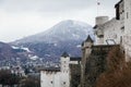 Panoramic top scenery of old town, viewpoint at Hohensalzburg Fortress, during cloudy and gloomy winter day, mountains under snow Royalty Free Stock Photo