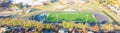 Panoramic top view school football field with running track, soccer goal, artificial playing surface and colorful autumn leaves Royalty Free Stock Photo