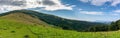 Panoramic ukrainian countryside with green meadows and hills under blue sky